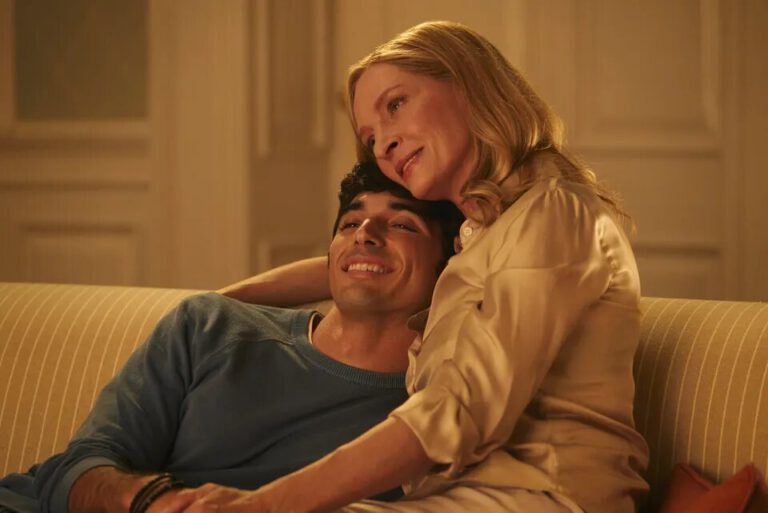 Uma Thurman and Taylor Zakhar Perez in a still picture for the new movie red white and royal blue sitting on a couch aughing and embracing eachother